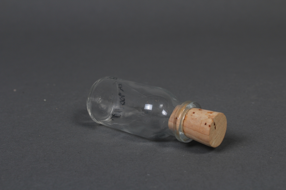 Liten flaske i klart glass, med kork.
Gjenstanden har vore brukt i samband med dyrlegearbeid på Jæren.
