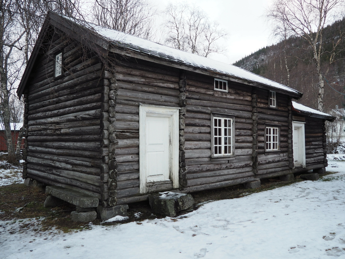 En av de eldste bygningene vi kjenner til fra det som i dag kalles byflaten i Mosjøen. Skal være oppført i 1750 i det som i dag er Strandgata, som husmannsbolig.  Flyttet og oppført på bygdetunet i 1972, etter tolking av hvordan den opprinnelig skal ha sett ut. 
