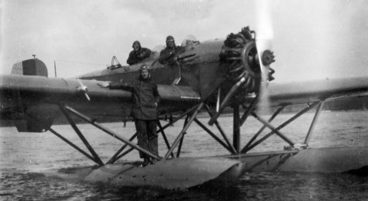 Flygplan S 5 Heinkel He 5 Hansa på vatten inför start. Tre flygare vid flygplanet. 1930-tal.