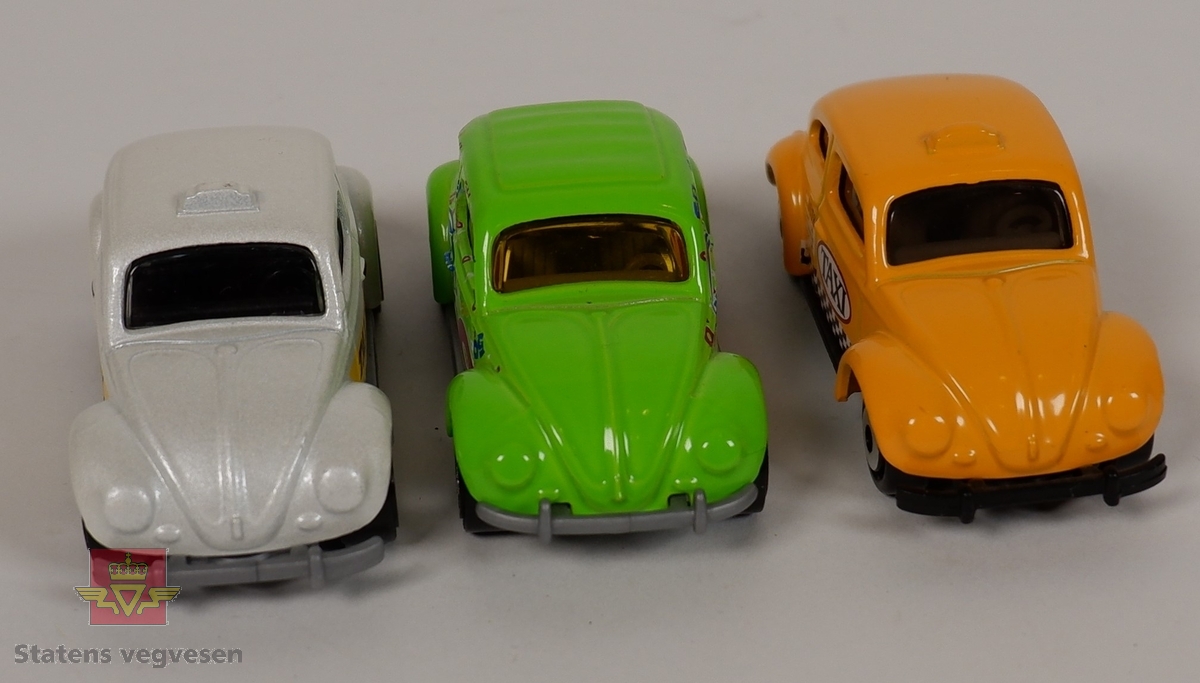 Tre miniatyrmodeller av Volkswagen Beetle. Hovedfargen på bilene er hvit, gul og grønn. To av bilene har påskriften TAXI. Bilene er laget hovedsakelig i metall med plastunderstell og detaljer. Skala 1:58.