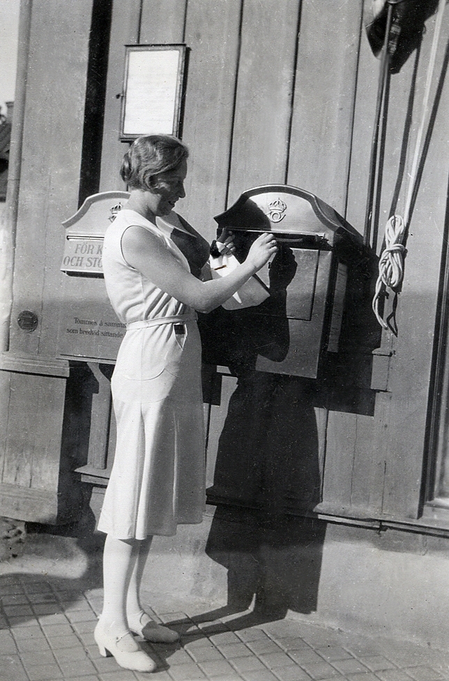 En kvinna lägger på ett brev i en brevlåda.
Text under fotot: "Gerda och skuggan av en polis".