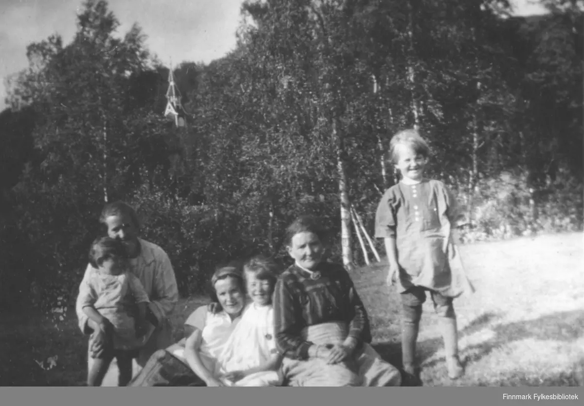Fra venstre: Nanna Methi, jente i Nannas fang vet vi ikke navnet. Astrid Mikkola, ei jente (?), eldre kvinnen heter Sofie Josefine Mikkola og jente som står heter Erna Methi. Neiden kirke i bagrunnen.