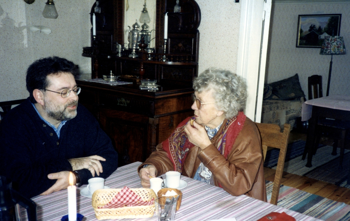 Söndagskaffe i Hembygdsgården Långåker 1:3, 1980-tal. Staffan Bjerrhede och Stina Svensson sitter och samtalar över var sin kopp kaffe.
