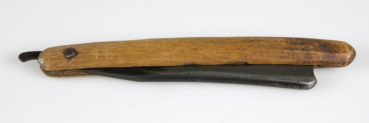 Hopfällbar rakkniv med skaft av brunbetsat trä och kraftigt blad av stål stämplat: PATENT. STEEL, JOHN BA...