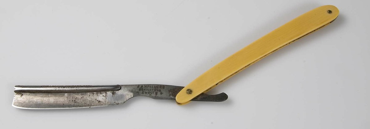 Hopfällbar rakkniv med skaft av gult ben och blad av stål med skena över ryggen med text: Trollhätte Diamant-stål, stämplad J A H Fullberg, Eskilstuna, Sweden.