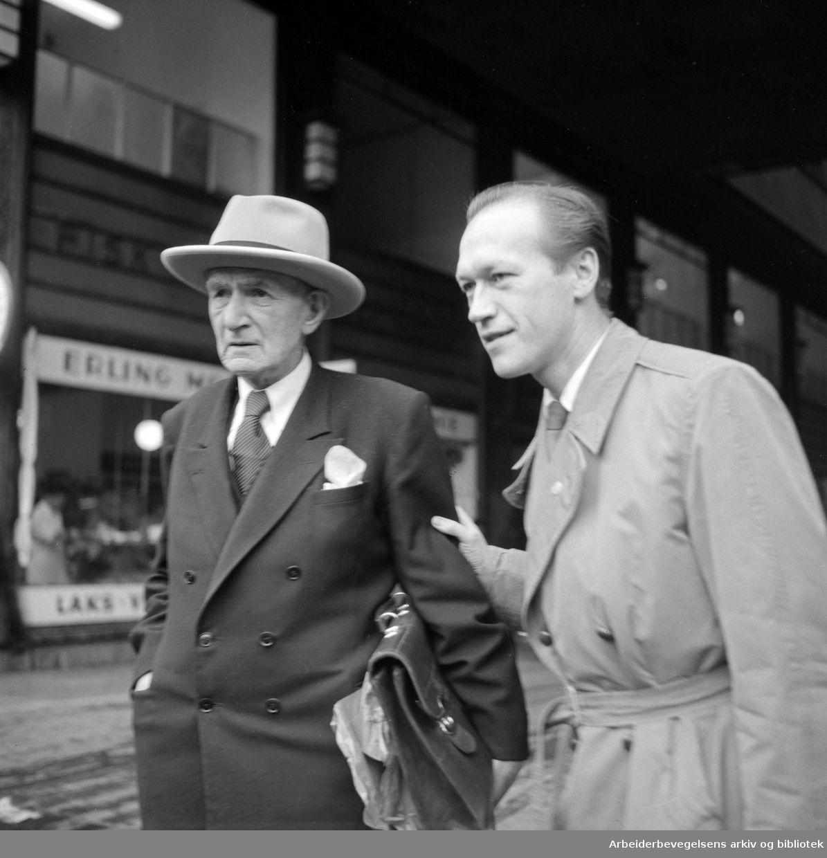 Forfatteren Johan Falkberget (til venstre) og Arbeiderbladets journalist Leif Herbrand Eriksen i Folketeaterpassasjen. Oktober 1954.