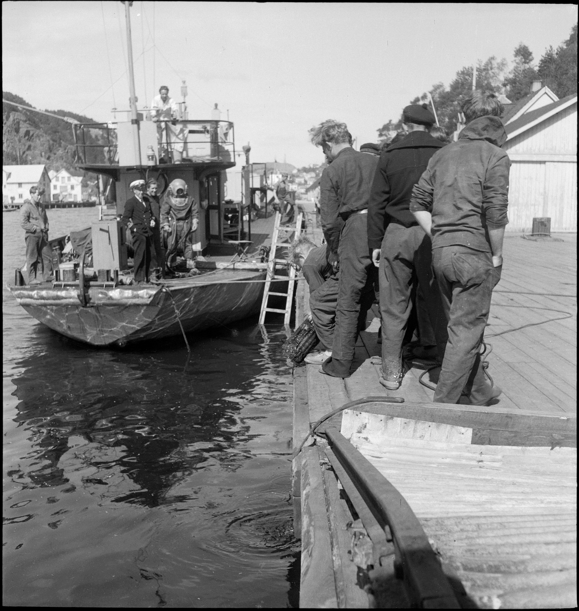 En dykker har tatt opp en granat fra kaien i Egersund. Mange menn har kommet for å se.