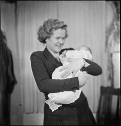 En kvinne med et nyfødt barn i armene. Bilde nr. 7 er av en 