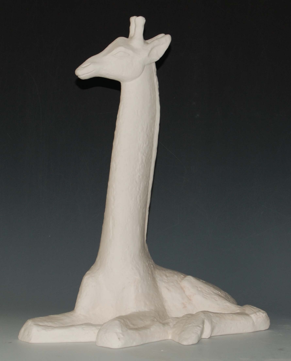 Vit liggande giraff, modellerad i gips, med bottenplatta gjuten i gips. Giraffen är en fullskalemodell till den liggande giraffen i stengods. Formgivare Lillemor Mannerheim.