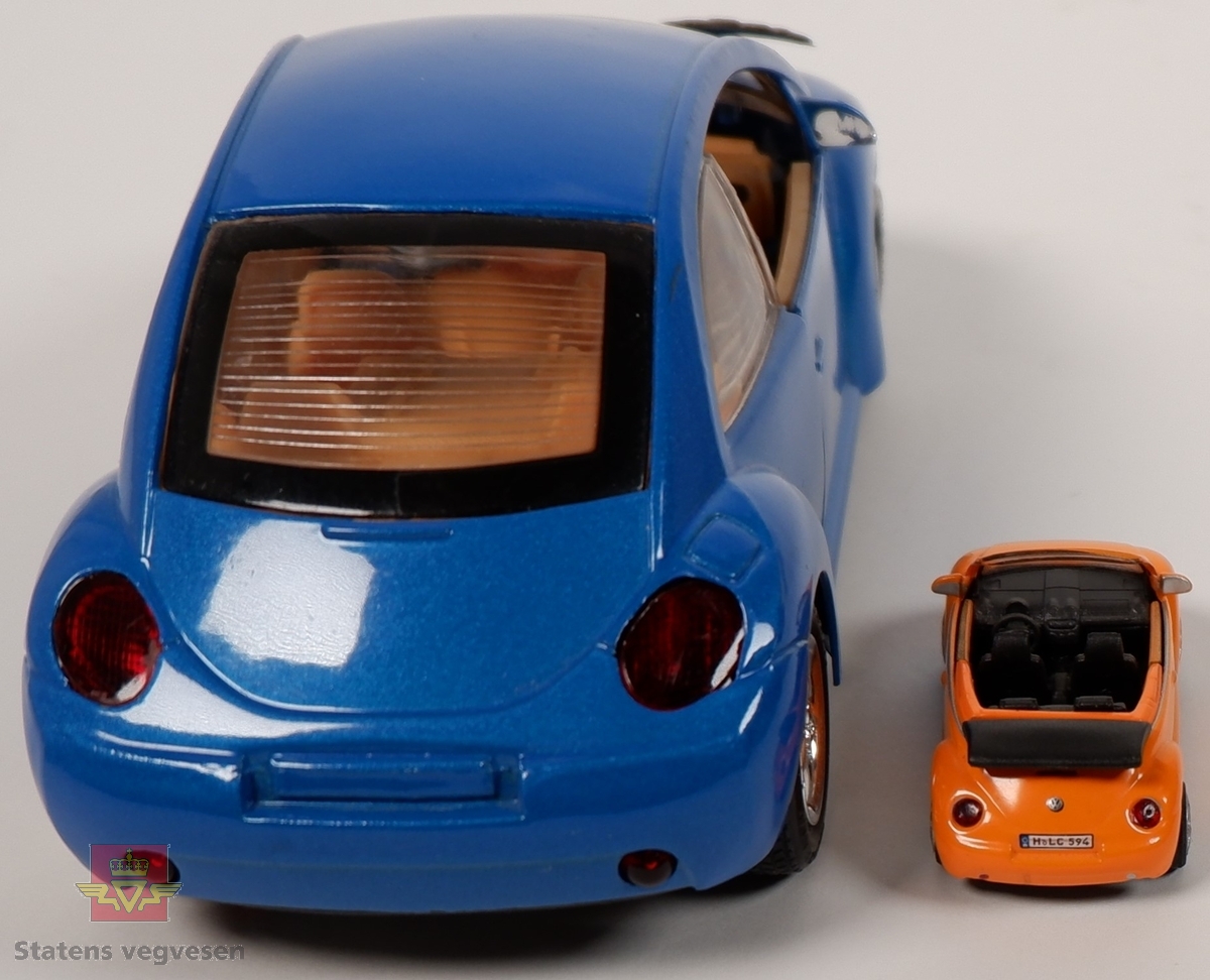 To miniatyrbiler av Volkswagen New Beetle. Miniatyrene har hovedfargene blå og oransje, og er i forskjellige størrelser. Bilene er laget av metall med understell og detaljer i plast. Den blå bilen er merket med skala 1/24.