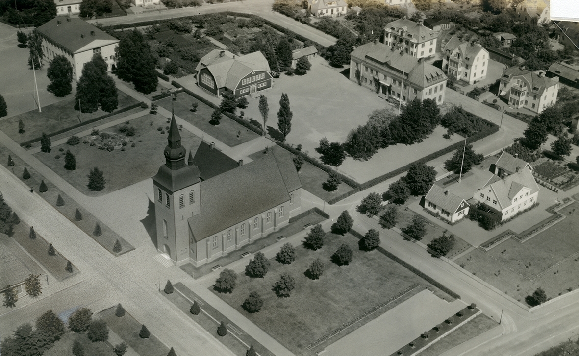 Flygfoto över Nybro kyrka. Bilden visas obeskuren och beskuren till vykort.