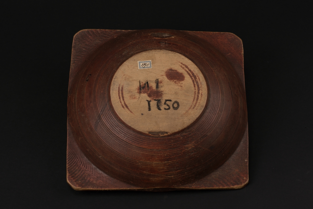 Rödfärgad snibbskål av trä.
Rund, svarvad skål, med fyra utskjutande snibbar. Spår efter svart dekor på snibbarna.
Inuti skålen finns initalerna H.P.S. och årtalet 1755 ditmålat i svart. Under skålet är initialerna N I och årtalet 1750 inristat.