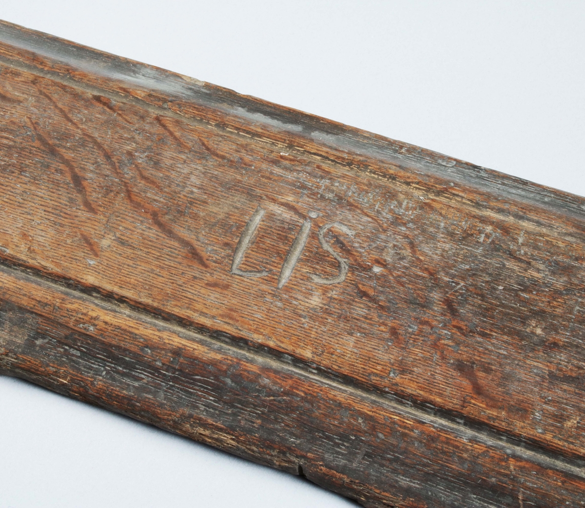 Kaveldon. (Mangelbräde och kavel). I brunbetsad ek. Infällt och träpluggat handtag med litet träbortfall. (Lätt maskstunget). Brädet med fasade och profilerade kanter, samt märkt "LIS" på ovansidan som är slät. Samhör med svarvad kavel, märkt: BM 8088.

Mangelbräde eller kavelbräde är ett redskap av trä som använts för mangling av textilier. Mangelbrädet användes tillsammans med en kavel, en slät rulle av trä. Den textil som skulle manglas, rullades upp på kaveln, på ett bord eller annat slätt underlag. Under hårt tryck, rullades kaveln med hjälp av mangelbrädet, fram och tillbaka över bordet. (Wikipedia)