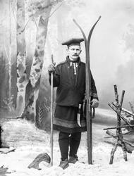 Løytnant Peters iført skidrakt og skiutstyr i fotoatelier. S
