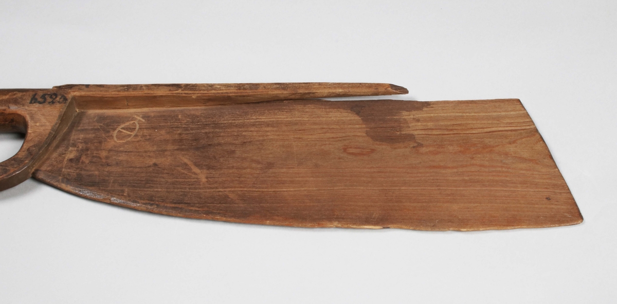 Skäktkniv i brunbetsat trä. Svärdform, bredast mot spetsen; tunnt; baken med utsparad tjock kant (skadad). Märkt med anonymt, skuret bomärke?

Funktion: Skäktkniven användes genom att lin spändes upp över en skäktstol, eller annan vertikal bräda, och därefter bearbetades linet med skäktkniven tills linet var fritt från vedämnen. (Wikipedia)