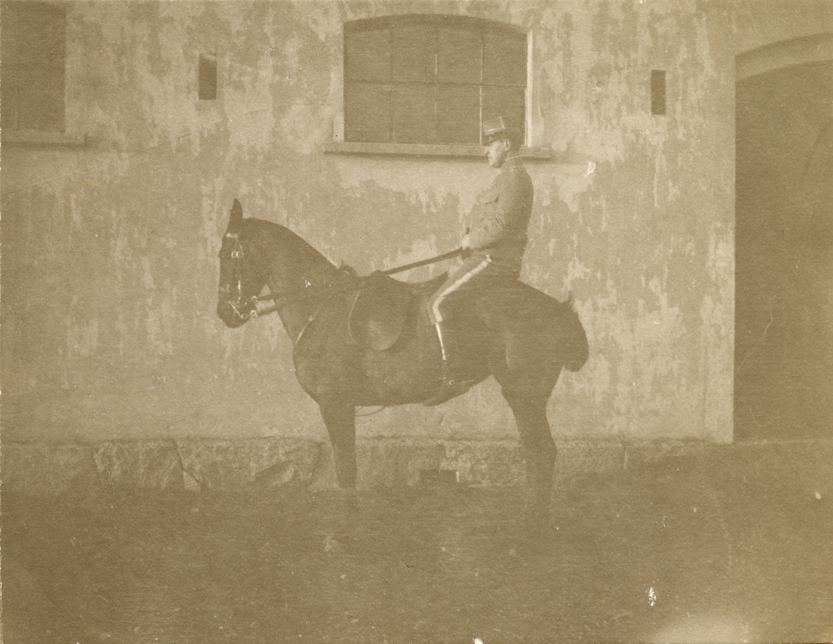 Soldat till häst framför byggnad.