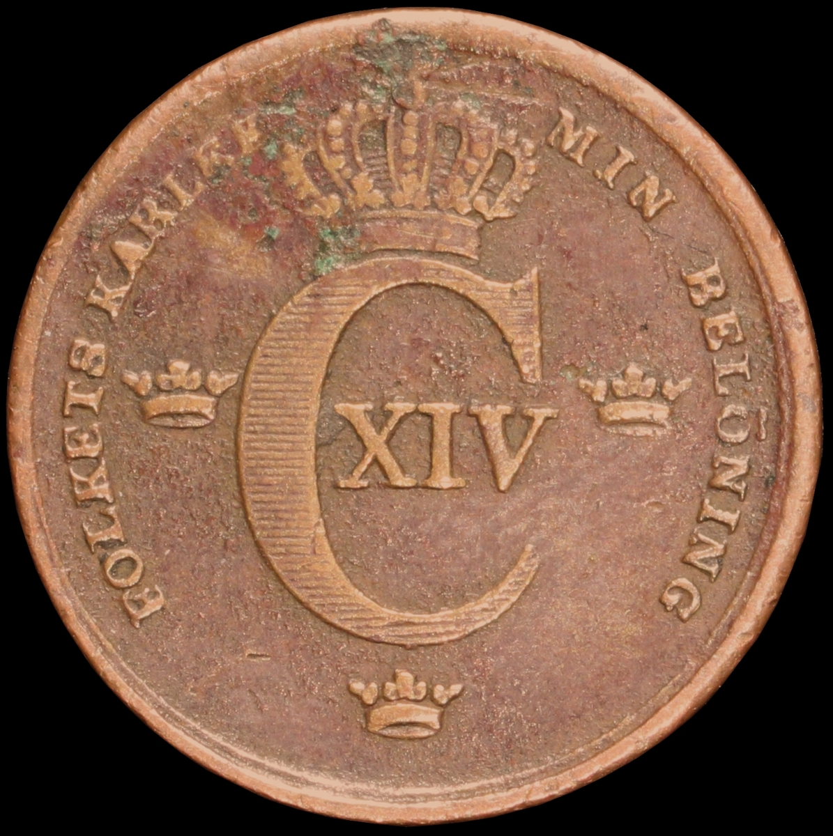 Mynt med valören 1 skilling banco. Åtsidan har Kung Karl XIV Johans emblem och valspråk. Frånsidan visar valören, två korslagda pilar samt en växtkrans.