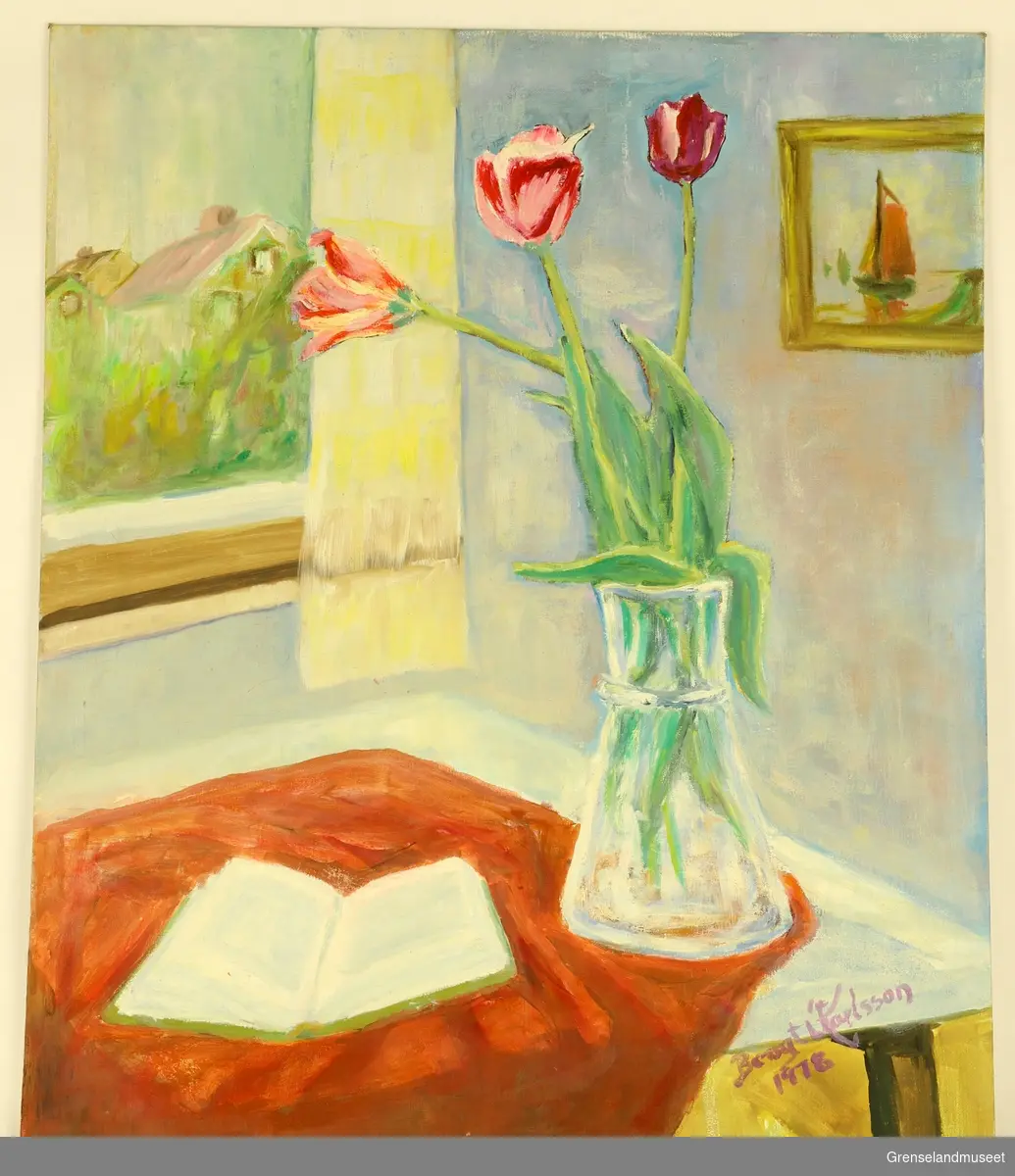 Stilleben. Tulipaner i en vase på et bord, en oppslått bok ligger ved siden av. Et maleri på veggen til høyre og bak ser vi ut av vinduet.