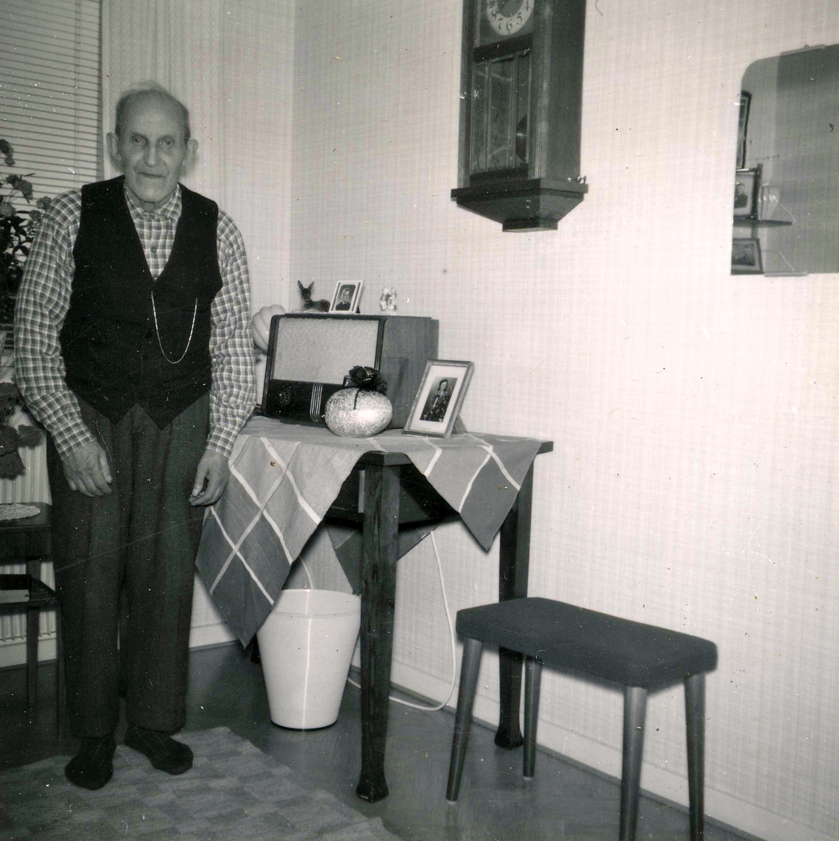 Robert Pettersson (1886 - 1968) står i sitt rum på Brattåshemmet år 1957. Robert arbetade som dräng på Ekans gård sedan 1912. Han avled på Brattåshemmet.