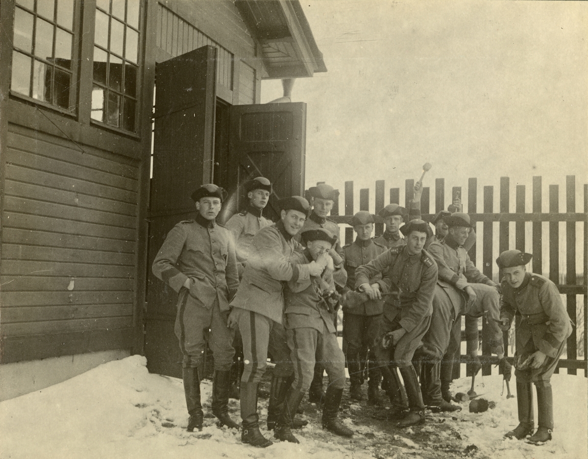 Gruppbild med soldater framför en byggnad.