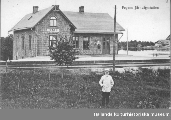 Vykort, "Fegens järnvägsstation".  Stationshuset uppfördes av Varberg-Ätrans Järnvägs AB och invigdes 1911 och ersatte det äldre. Stationen ligger vid sjön Fegen som skymtar till höger. I förgrunden står en man i ljus uniform.
Vykortsförlag: Svenska Litografiska AB Stockholm.