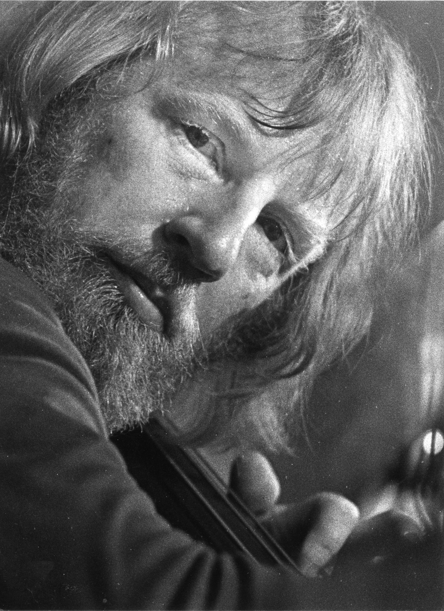 Bild på en man i långt hår och skägg som spelar på en kontrabas. Möjligtvis Anders Jormin.