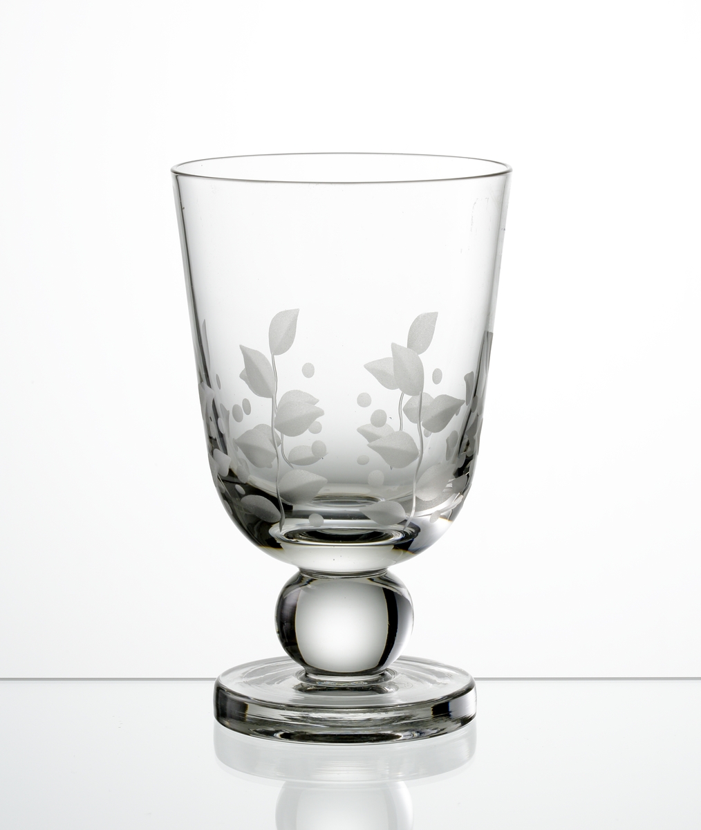 Design: Edward Hald.
Ölglas. Cylindrisk kupa med graverad bladdekor. Kulben med tjockare fot.