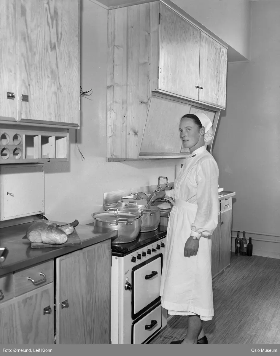 Oslo kommunale husmorskole, interiør, kjøkken, kvinne ved komfyr