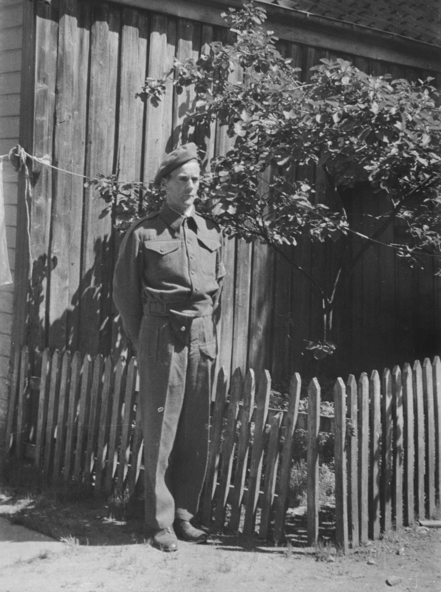Arne Feyling står i gården ved blåplommetreet i Elvegaten 9, mai 1945.