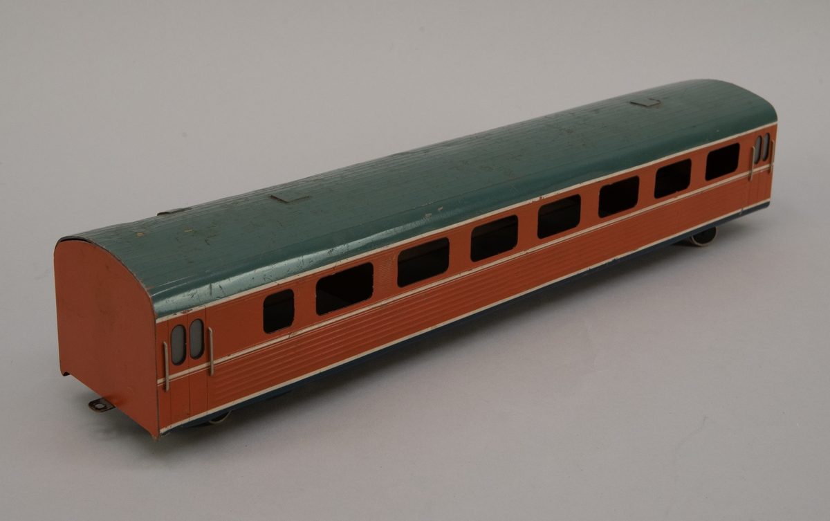 Modell i skala 1:50 av motorvagn UBoa2, X9M. Mellanvagn.
Orange med vita linjer och grågrönt tak.