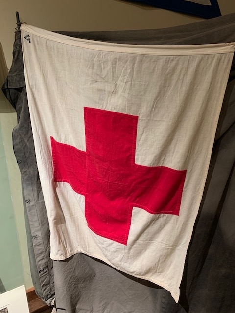 Flagga 
Vit botten med rött kors, för sjukvård på fält
Märkt med tre kronor