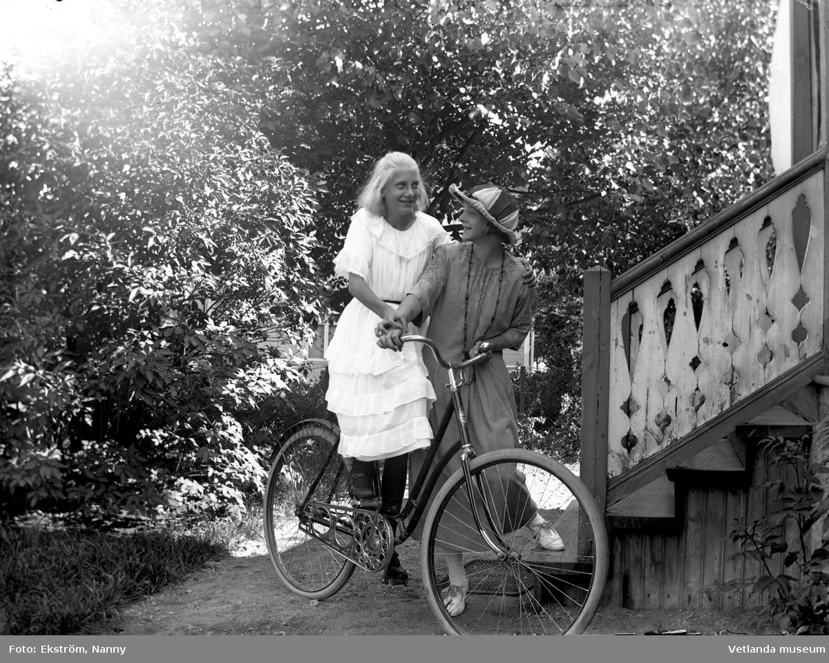 Anna Karin och en oidentiferad flicka med en cykel. Anna Karin var dotter till fotografen Nannys syster Amy. Bilden är tagen framför fotoateljén.
