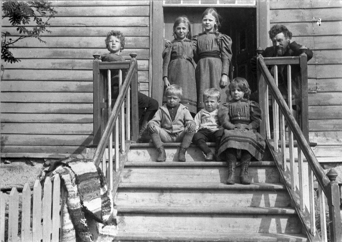Sogneprest Peter Bugge med barn, fotografert på trappa til Kvæfjord prestegård.