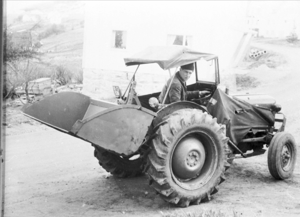 Traktor med bakmontert tippbar skuffe.
