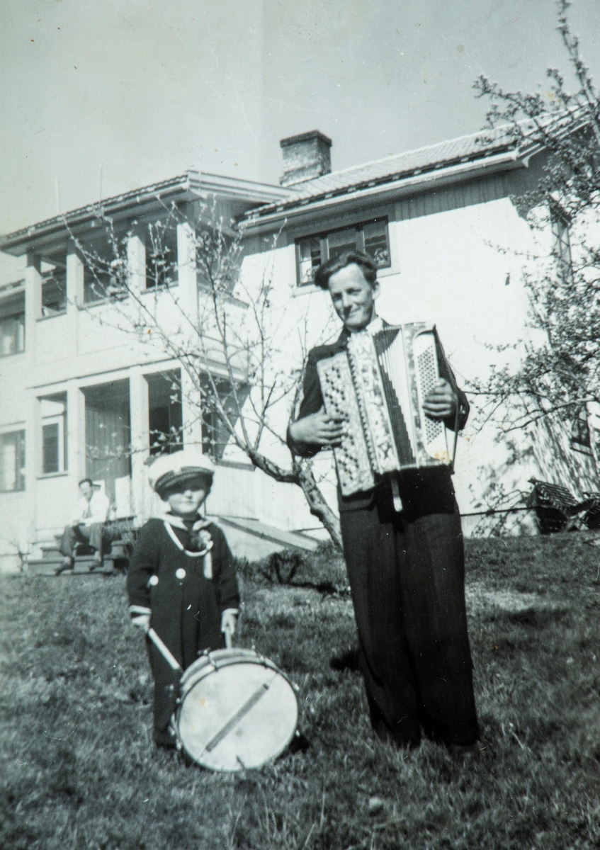 Per og Øystein Mæhlum, 17. mai 1951 i hagen på Tronsbakken i Vallset. Øystein med tromme, Per med trekkspill.