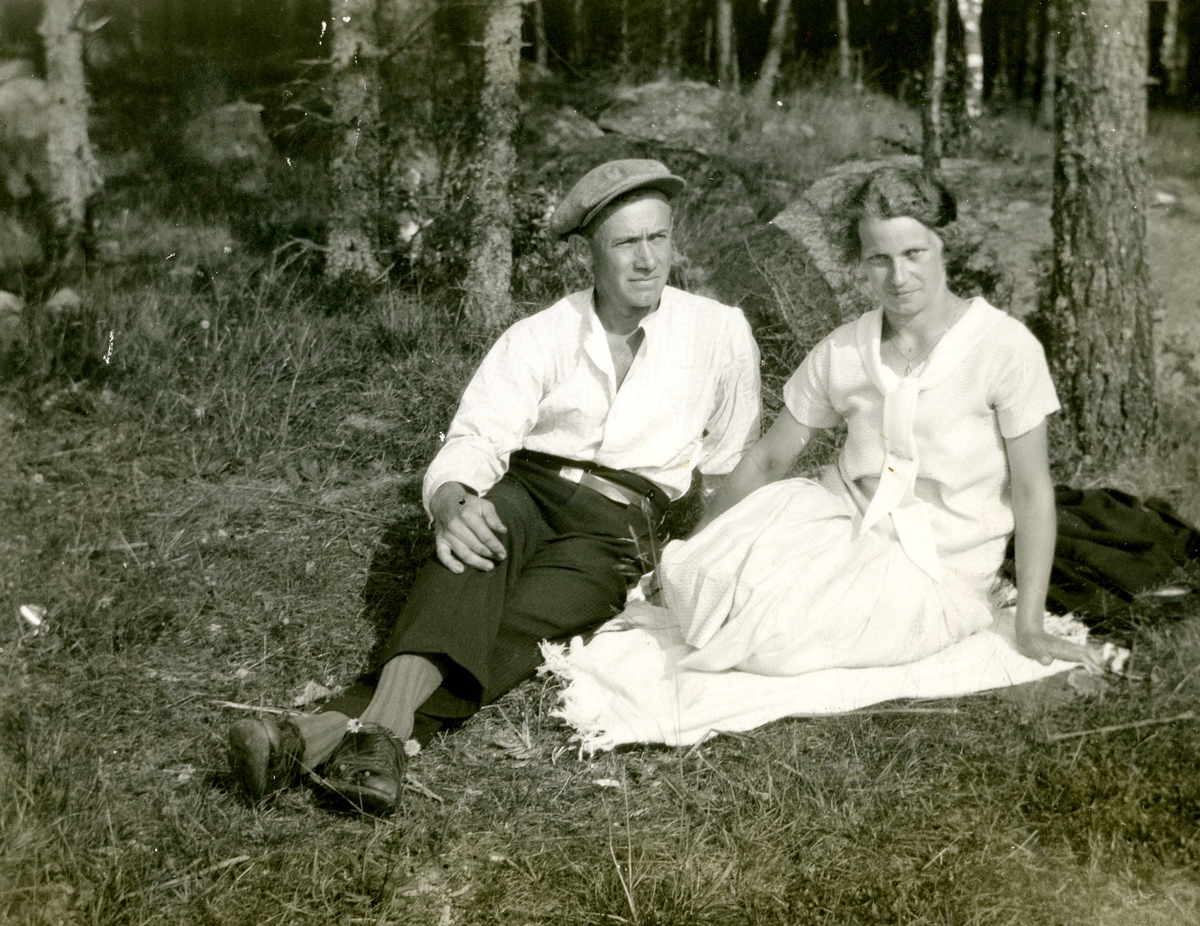 Paret John Johansson (1898 - 1966) och Ingeborg Gustavsson (1901 - 1987, gift Johansson) sitter i gräset vid Kållered Stom "Nygård" okänt årtal.