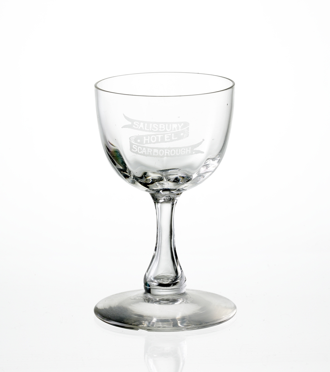 Design: Okänd. 
Sherryglas på luftben och fot. Optikblåst kupa med etsat emblem: "Salisbury Hotel, Scarborough".