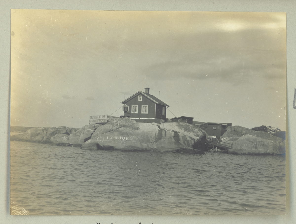 Bilden visar ett hus på Knippleholmarna i Älvborgsfjorden. På klipporna är olika minnesmärken inristat.
