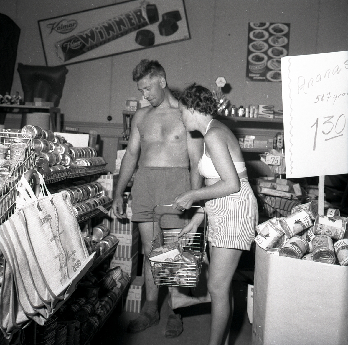 Personer vid en konsumbutik, under sommartid.