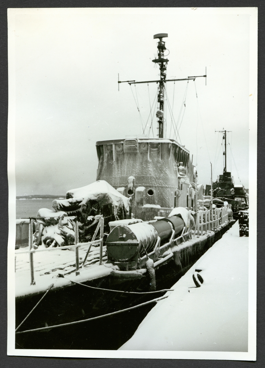 Bilden visar torpedbåten Perseus som ligger förtöjt vid kajen i vintertid.