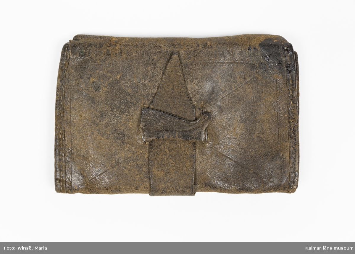 KLM 46489:18. Plånbok, läder. Större plånbok av brunt läder. Inuti fyra fack.