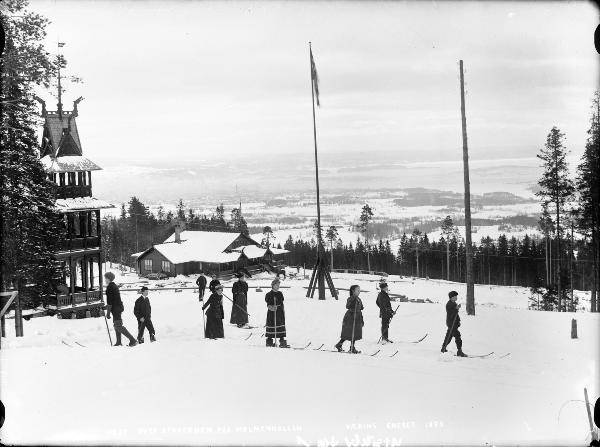 Skiløpere ved sportstuen på Holmenkollen med utsikt mot Fjorden.