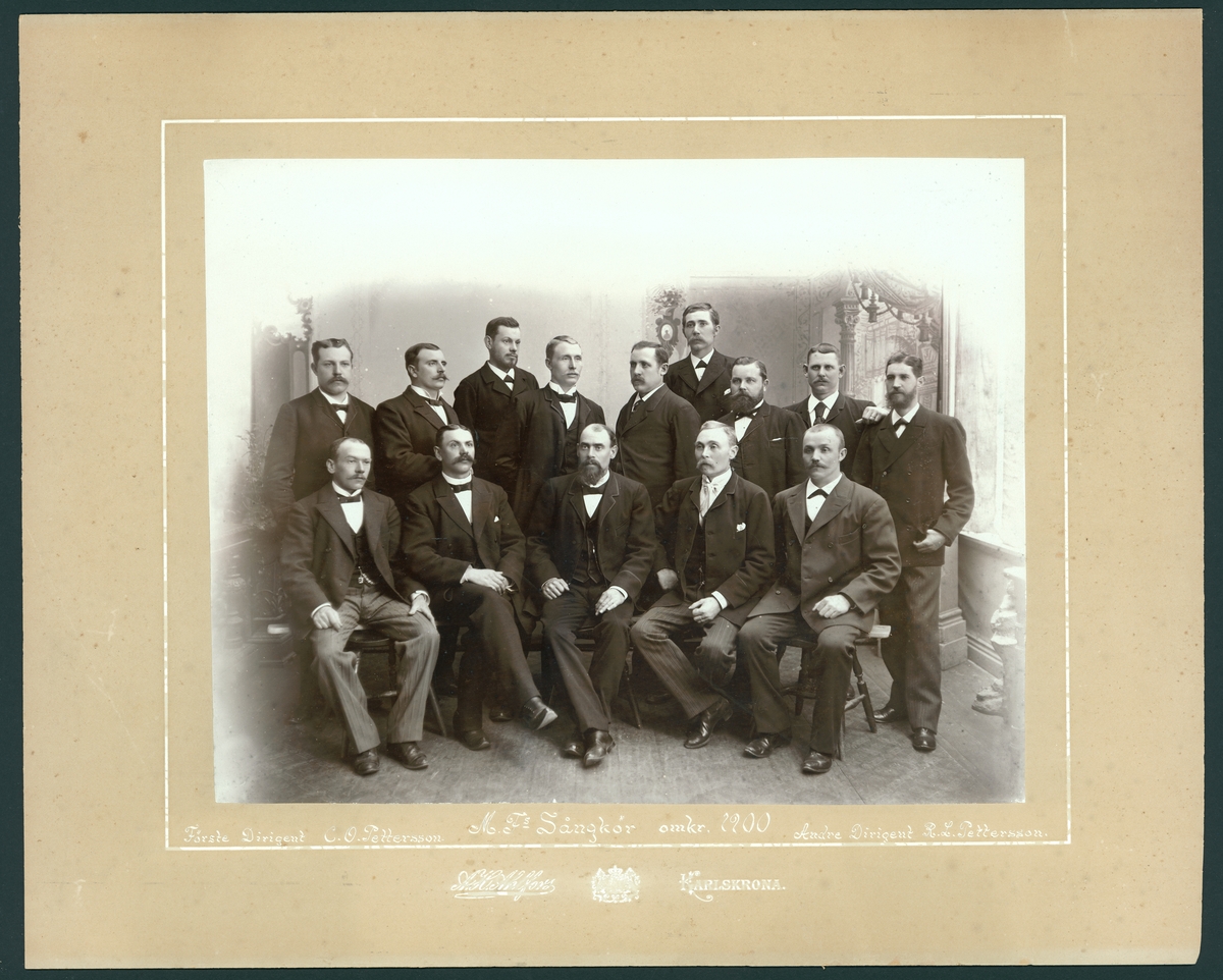 Bilden föreställer en grupportrett med MF:s sångkör omkring år 1900. Förste dirigenten C.O. Pettersson och andre dirigenten R.L. Pettersson är två av personerna på bilden.