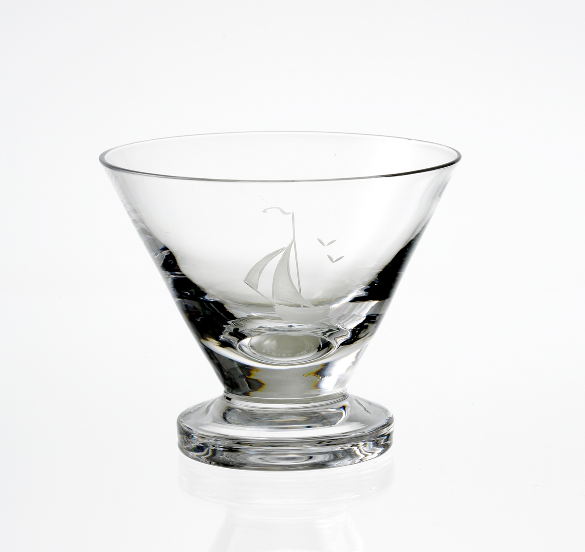 Design: Nils Landberg.
Madeiraglas. Konande kupa med cylindrisk fot. Graverad segelbåt på kupan.