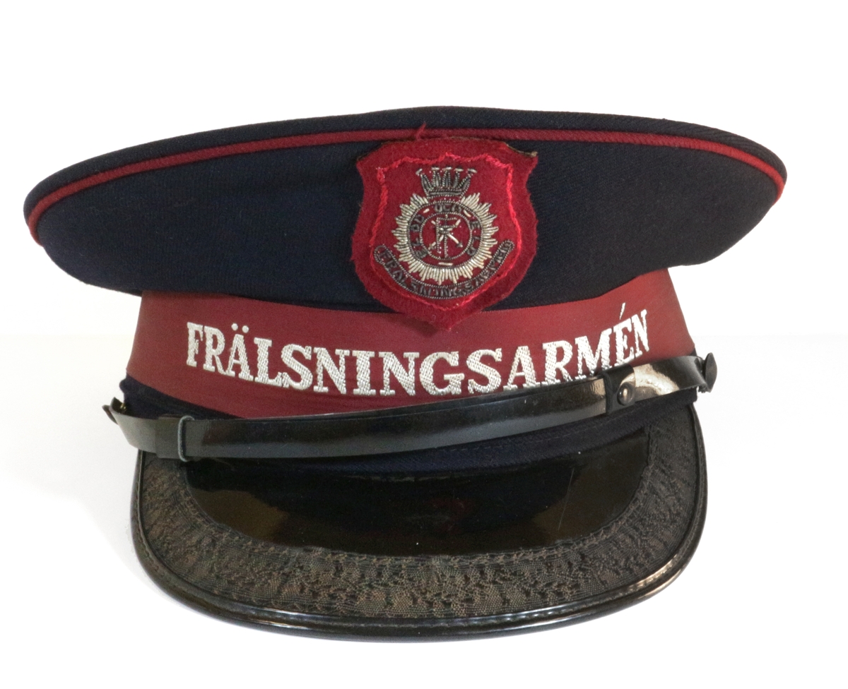 Manlig uniformshatt från Frälsningsarmén med svart skärm och dekorativ spets. Hatten stöds av läderkant och sidenfodring.