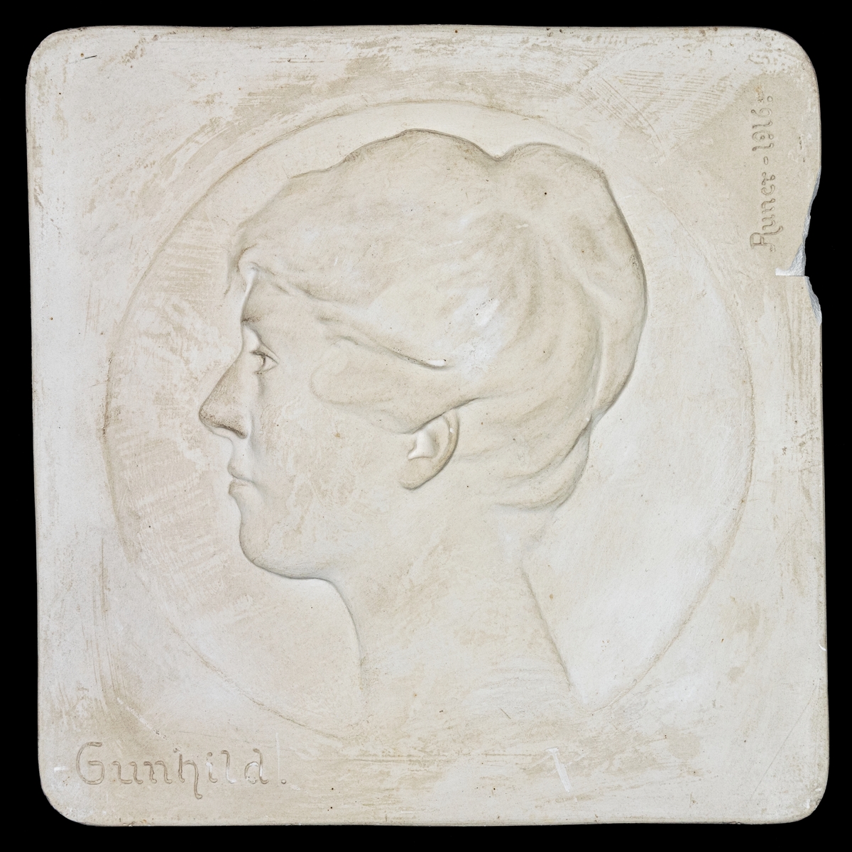 Porträttrelief föreställande Gunhild Toll f. Engwall.
Sign. John Runer 1916