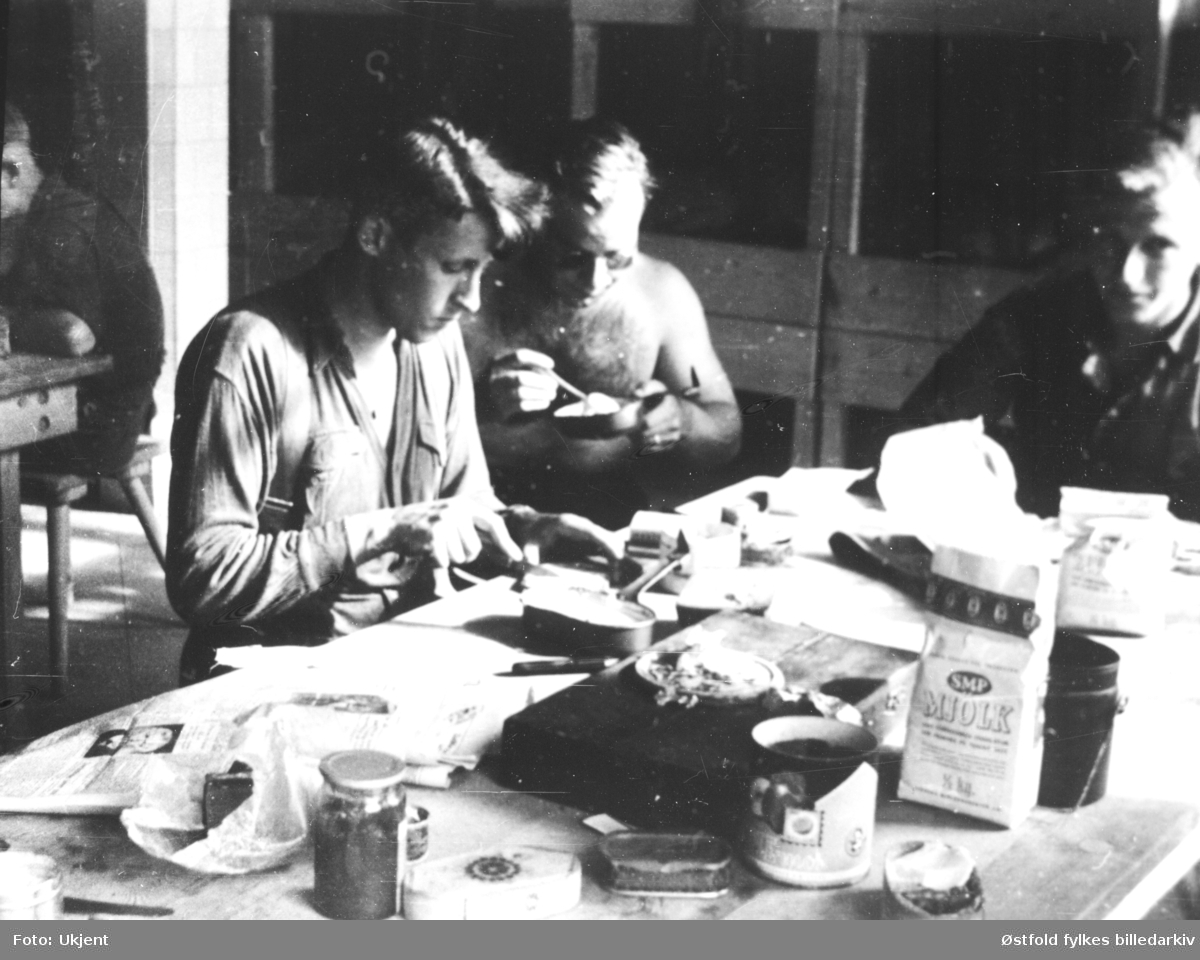 Norske studenter  i Tyskland for "omskolering" 1941-45. Måltid, tre menn spiser. Svensk Mjölk på bordet.