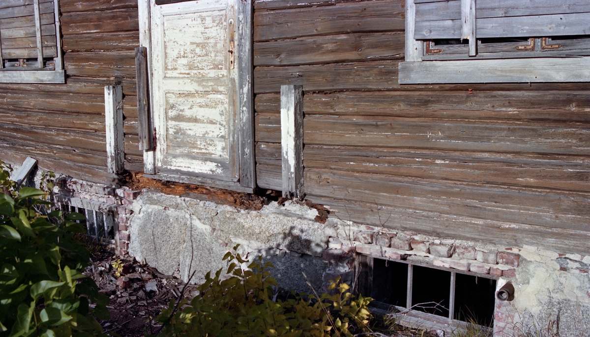 Forfallet på funksjonærboligen Skjærdal ved tidligere Klevfos Cellulose & Papirfabrik i Løten, Hedmark, slik det ble dokumentert i 1983. Fotografet er tatt mot den midtre delen av den sørvestvendte langveggen, der det var tydelige råteskader i svillstokken ved inngangspartiet. Årsaken må ha vært fukt som samlet seg der trappereposet, som da dette fotografiet ble tatt var fjernet, møtte veggen. 

Produksjonen ved Klevfos-fabrikken ble avviklet i 1976, etter å at man de siste årene bare hadde produsert papir av innkjøpt sulfittmasse de siste fire årene. I 1978 begynte en del entusiaster å arbeide for å bevare anlegget, som i liten grad hadde vært modernisert etter at fabrikkbygningen ble gjenoppbygd etter en brann i 1909. I 1983, det året dette fotografiet ble tatt, ble Klevfos Industrimuseums Venner stiftet. Denne organisasjonen tok fatt i restaureringsutfordringene i samarbeid med Riksantikvaren. Forvalterboligen Skjærdal var en av bygningene der forfallet var mest åpenbart. Den 16,5 meter lange og 8,9 meter brede bygningen ble reist i laftetømmer i 1919-1920. Fotografiene som ble tatt i 1983 tyder på at det da var lenge siden det hadde bodd folk i huset. Utvendig restaurering ble realisert i 1985-86. Etter restaureringa ble Skjærdal innredet med kontorer, kjøkken, arkiv, bibliotek, møterom og toalett for den lille staben som etter hvert kom til å drive museet.  De innvendige arbeidene var ferdige ved årsskiftet 1989-90.