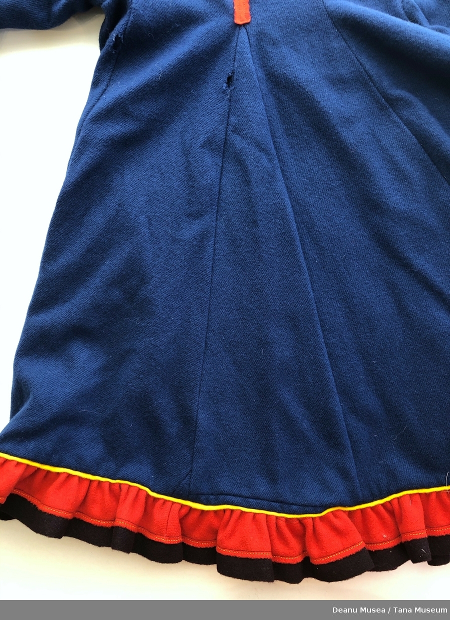 Mørkeblå jentekofte i ullklede fra Alleknjarg med røde pyntekanter. Rød holbi med gul og blå pyntekant.