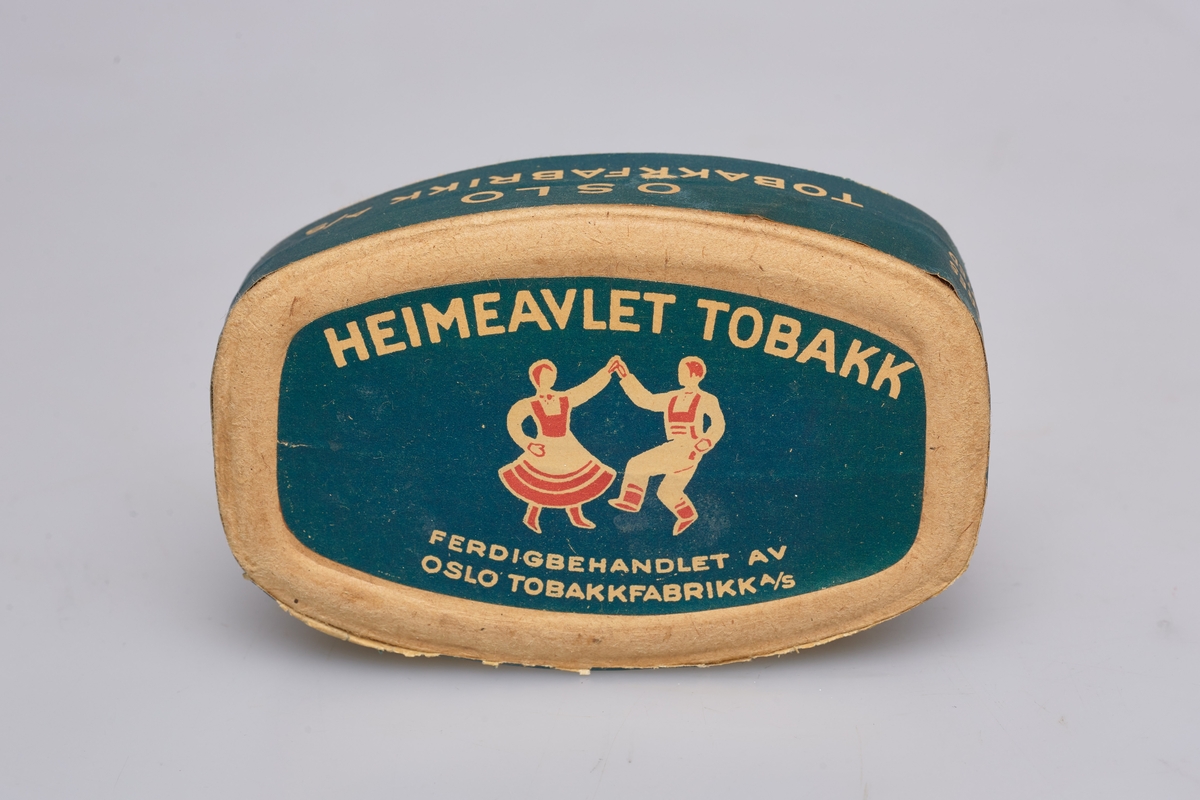 Tobakk i oval eske som er blå, rød og hvit. Norsk avlet tobakk, dvs dyrket i Norge som var vanlig under andre verdenskrig.
